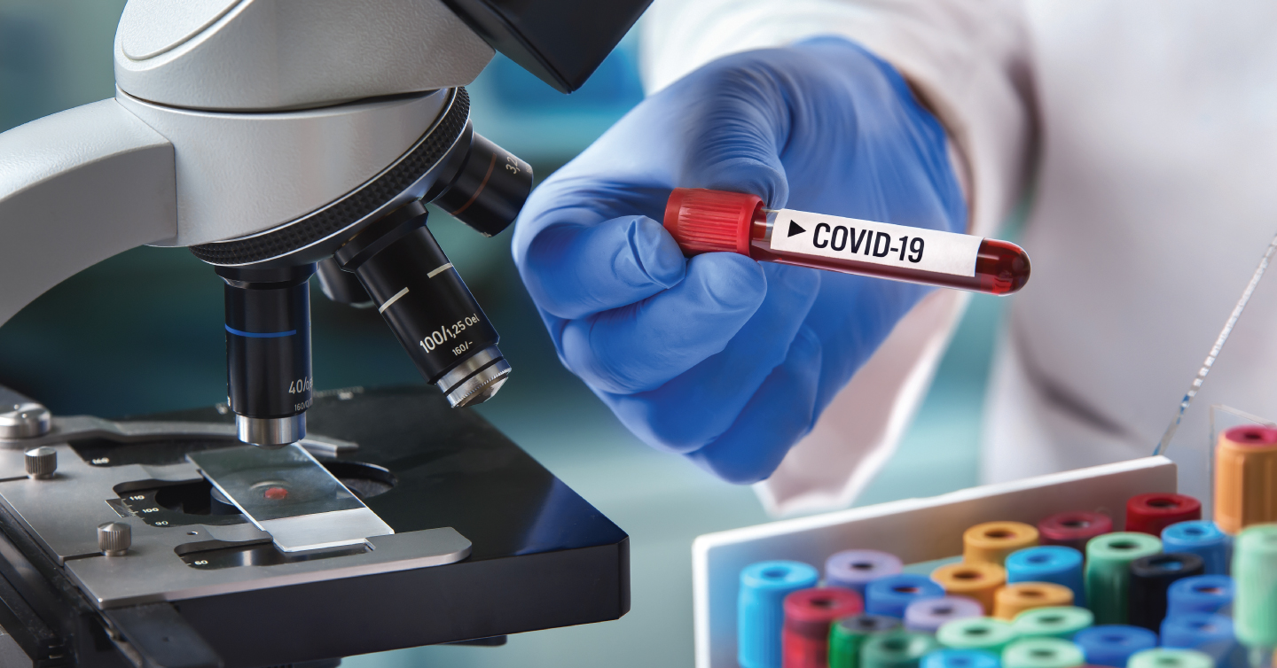lab scientist holding a COVID vial