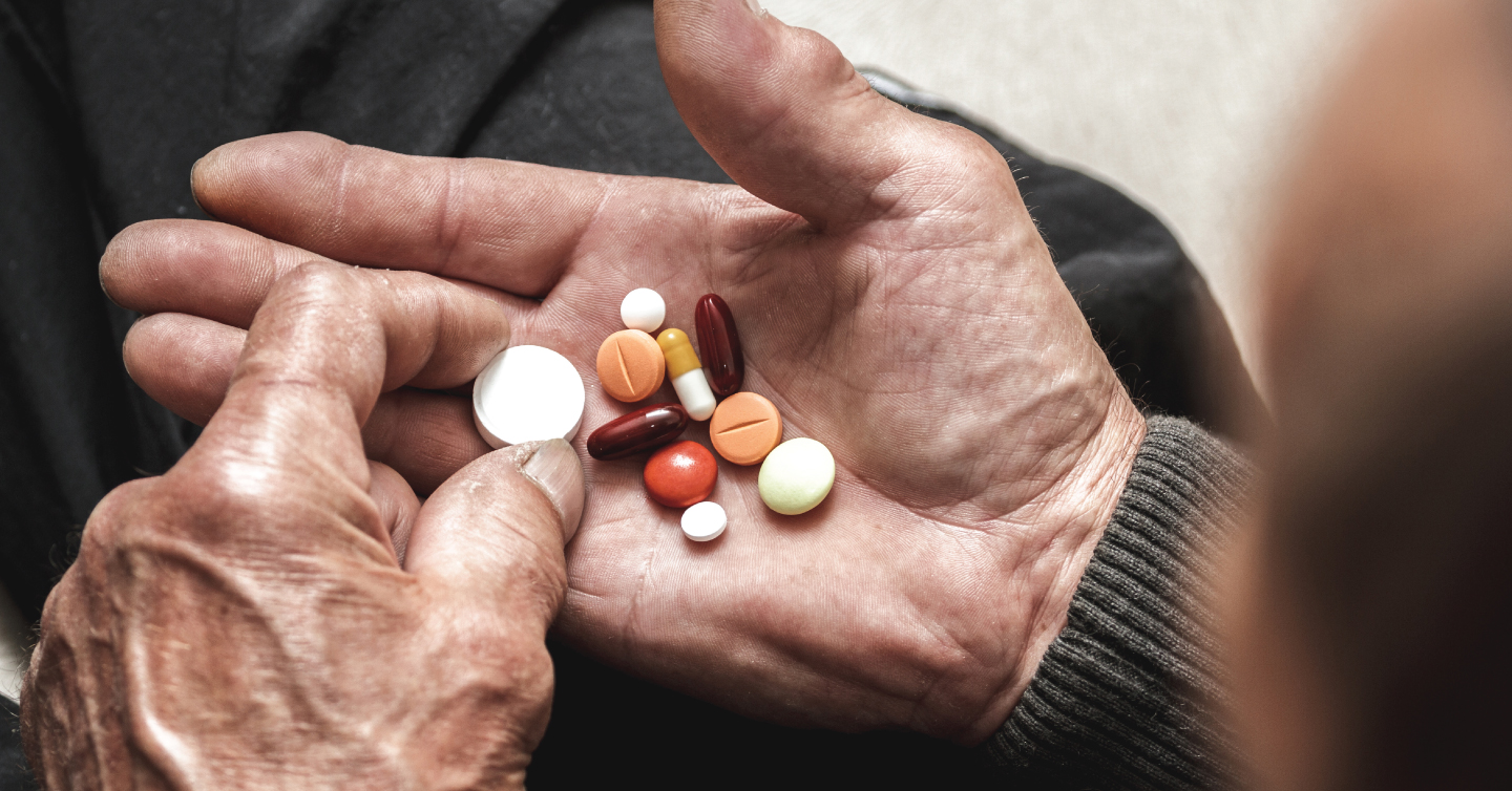 a person holding several different pills in their hand