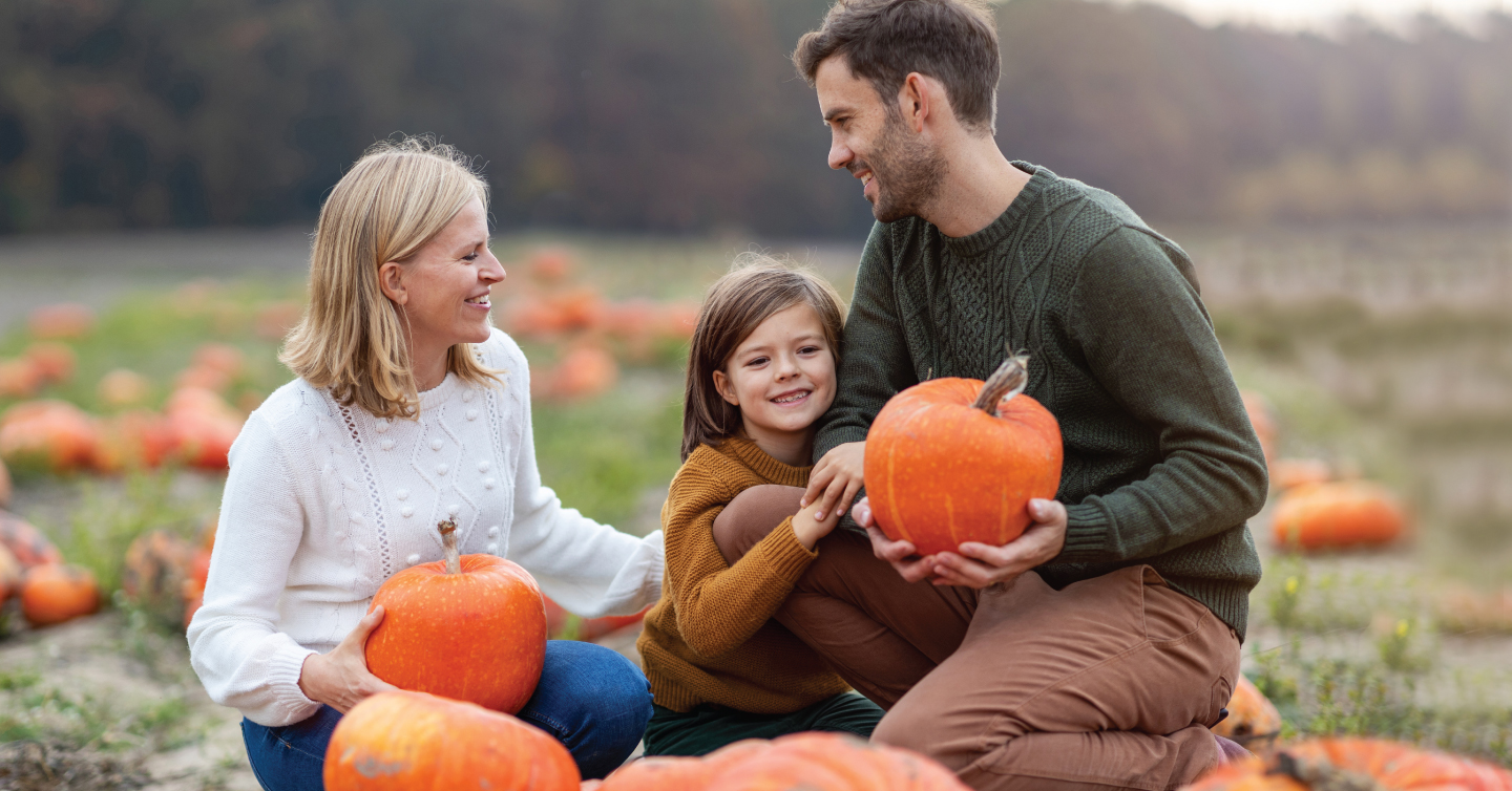 family picking out pumpkins at pumpkin patch