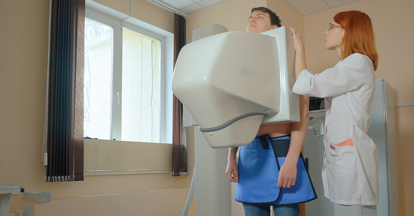 person standing for a mammogram with a doctor