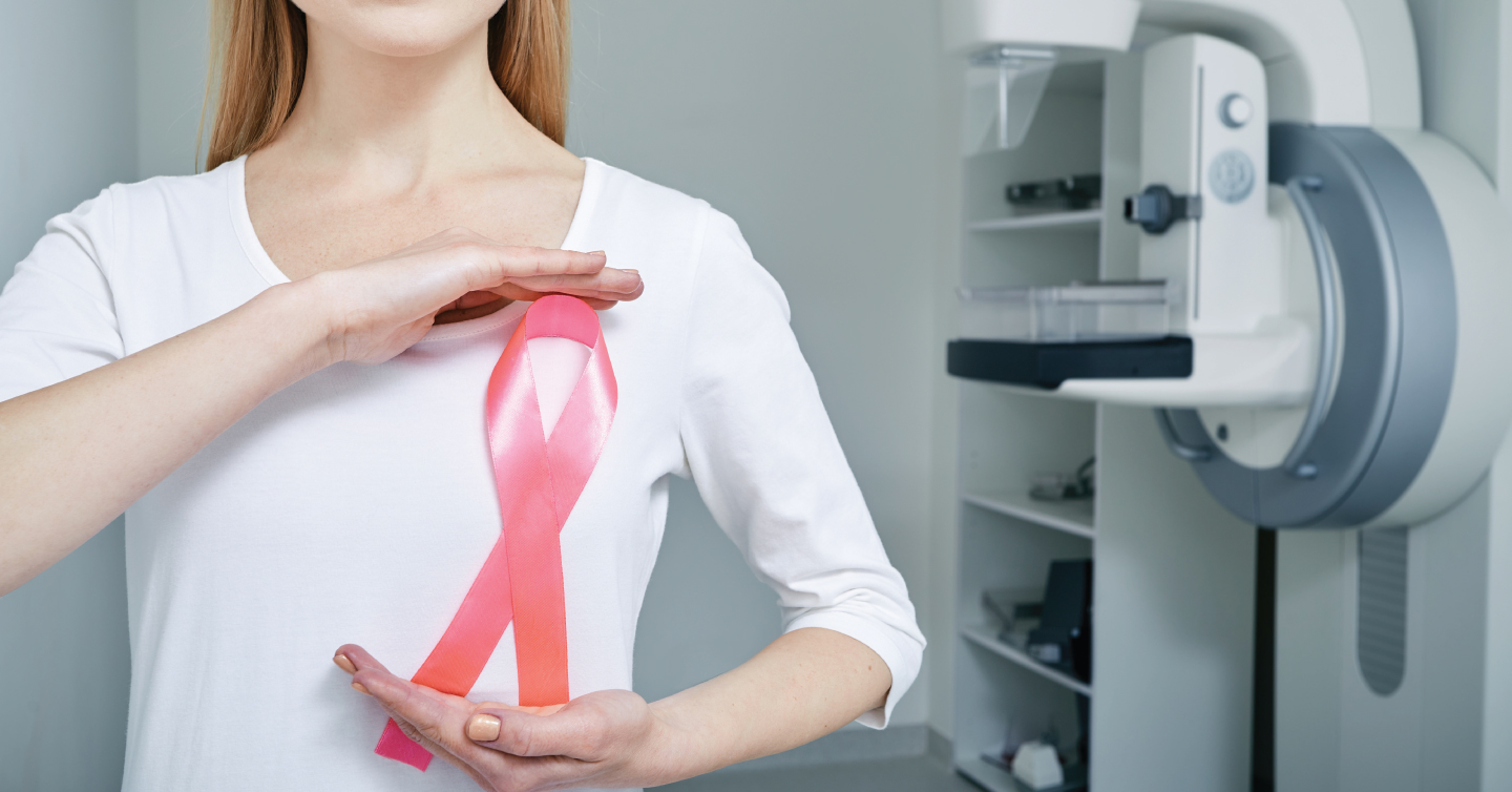 a person holding a pink breast cancer ribbon