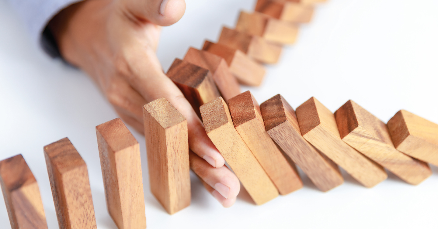 a hand blocking a series of falling blocks, representing fall prevention