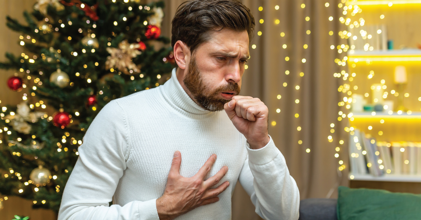 a man coughing and holding his chest during the christmas season