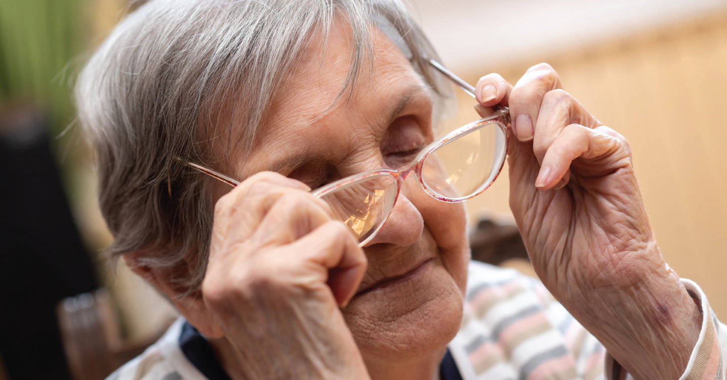 a senior woman putting on her glasses so she can see better to avoid falling
