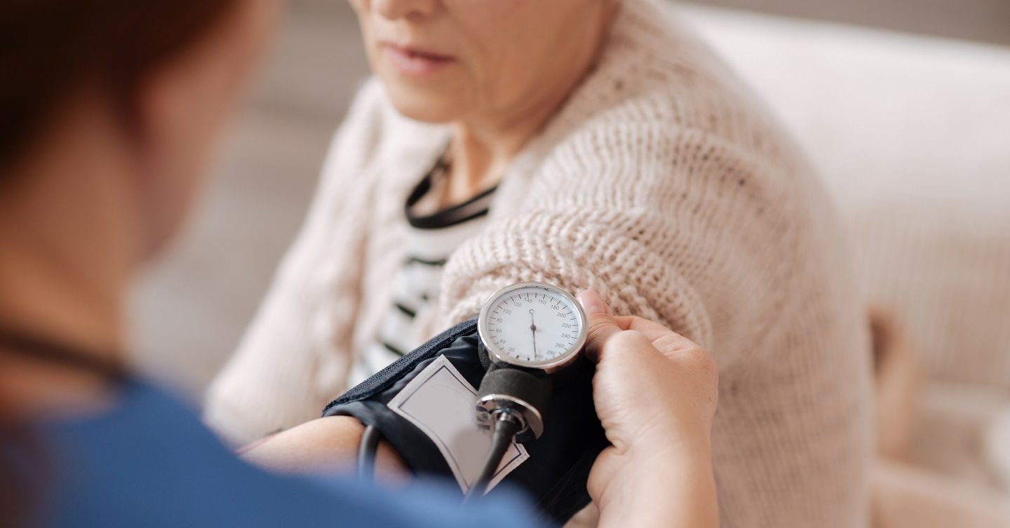physician checking a person's blood pressure with a cuff device