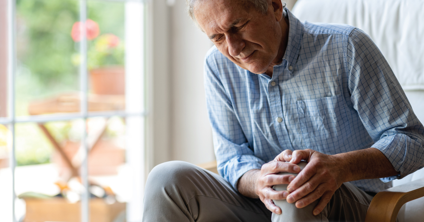 an older person with sore knees on the couch