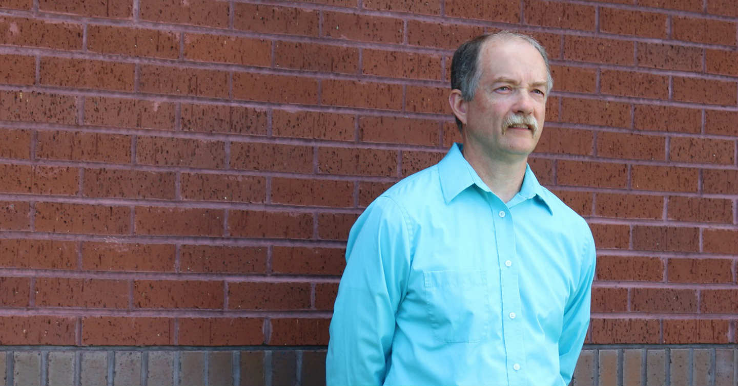 Jeff lanser standing next to brick wall at Network Health