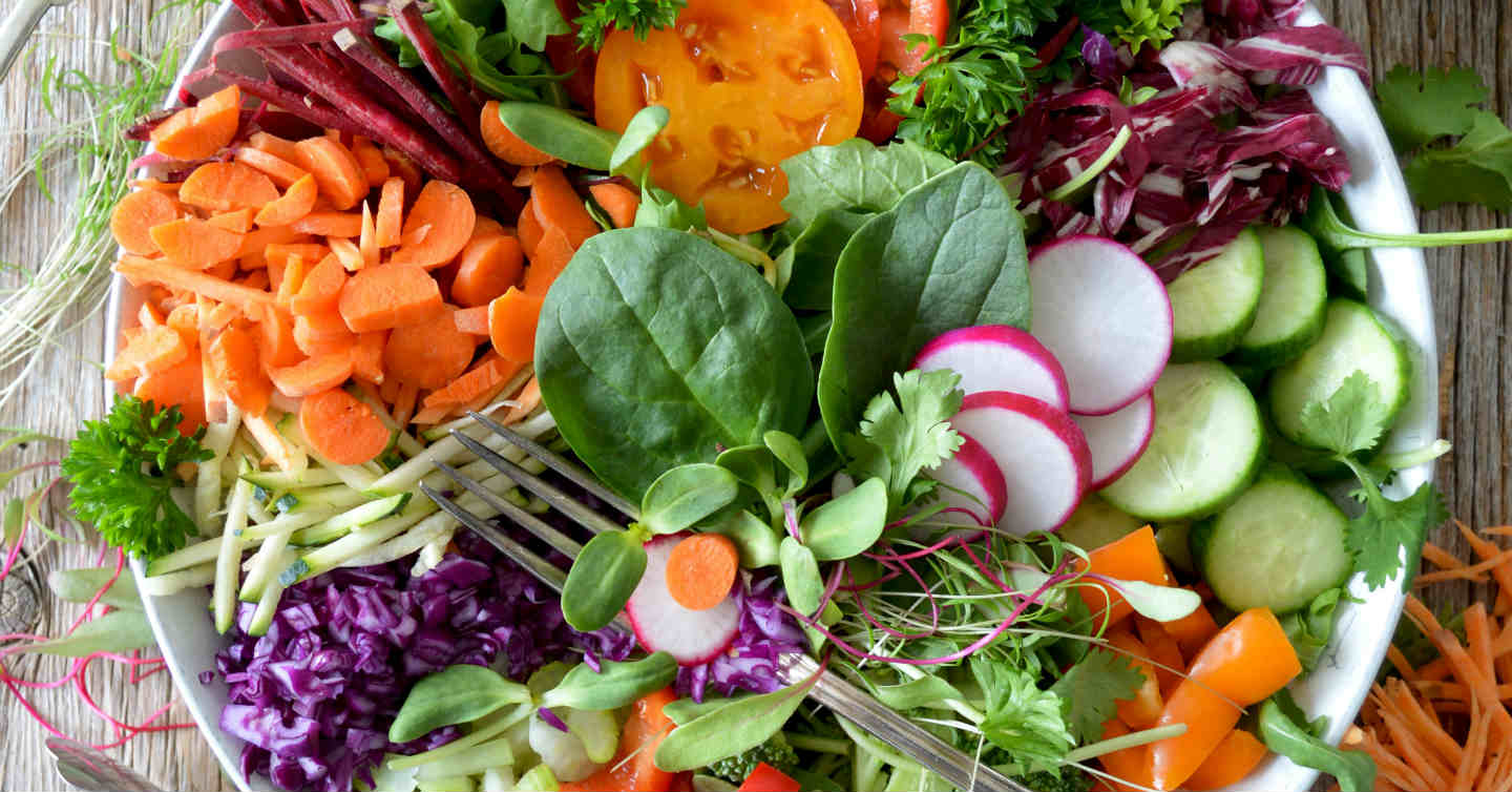 plate full of salad with spinach, radish and more