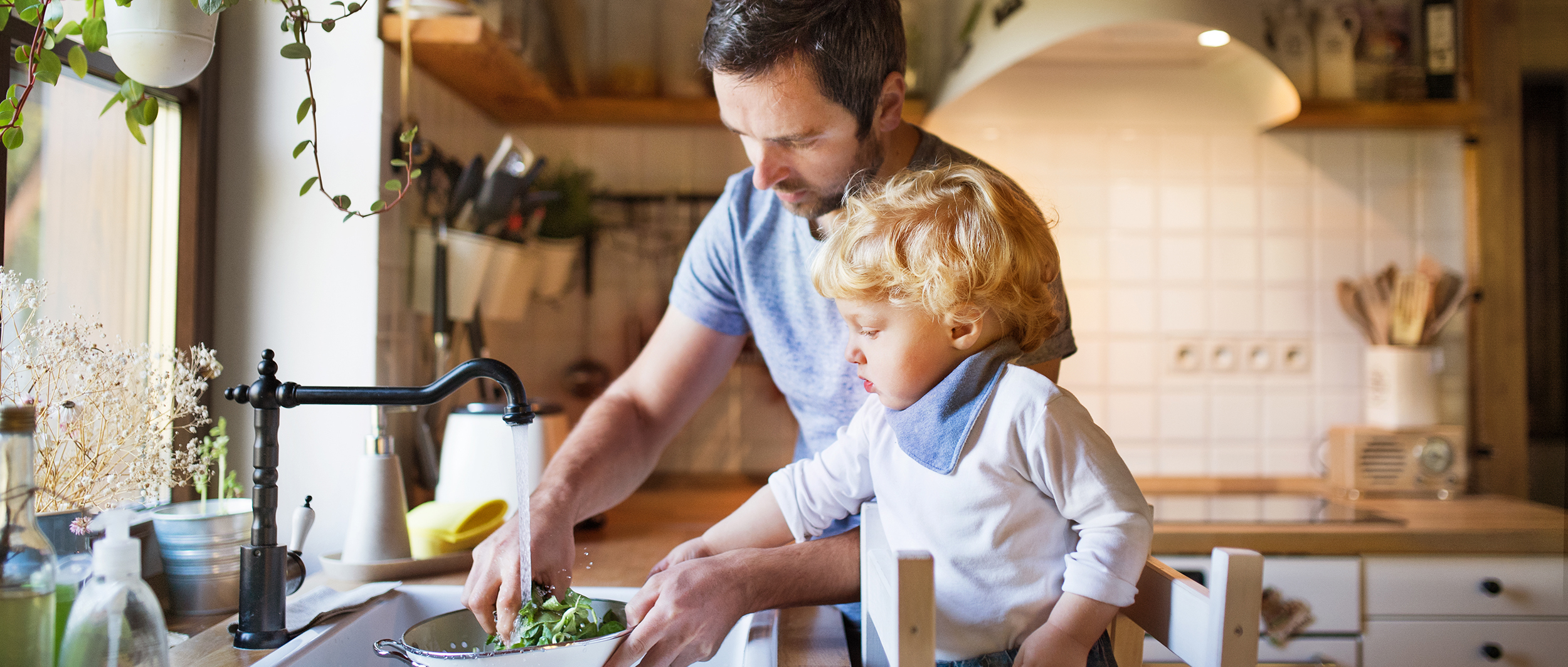 father washing asparagus with son for plant based diet