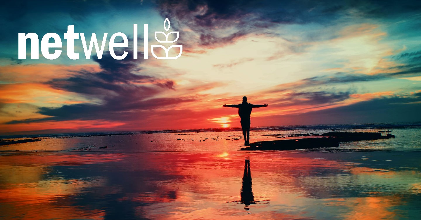 man standing on shore of sunset-lit beach
