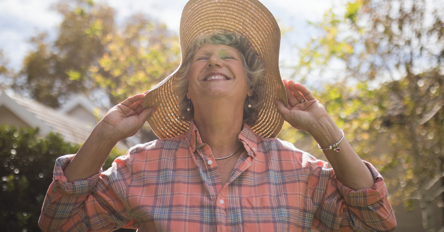 woman enjoying the sun while shielding herself from its harmful rays using a sun hat