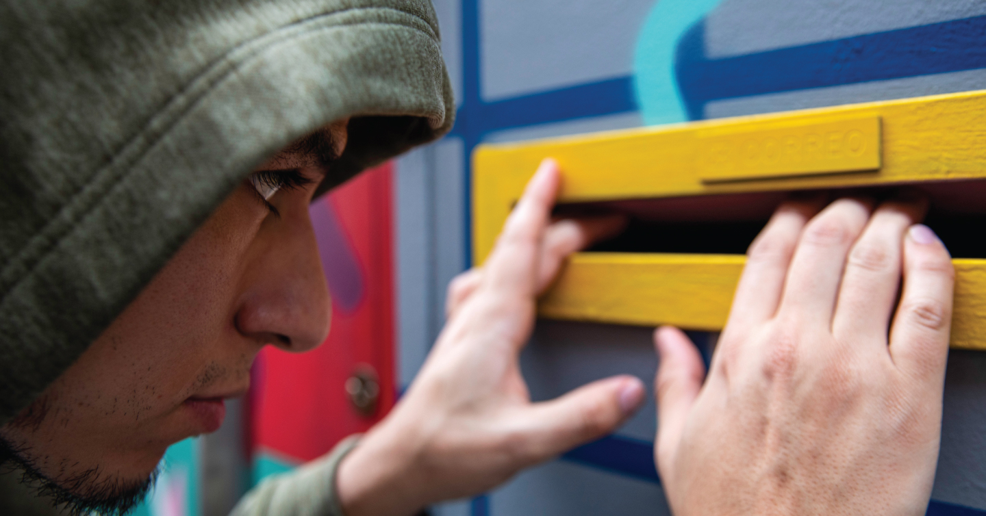 a thief peaking inside a mail box looking for health insurance documents