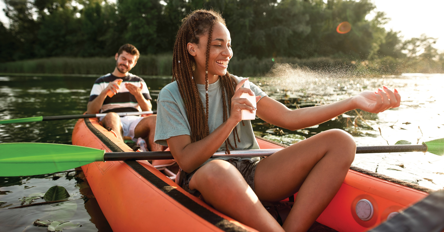 two people in a kayak applying sunscreen to protect their skin