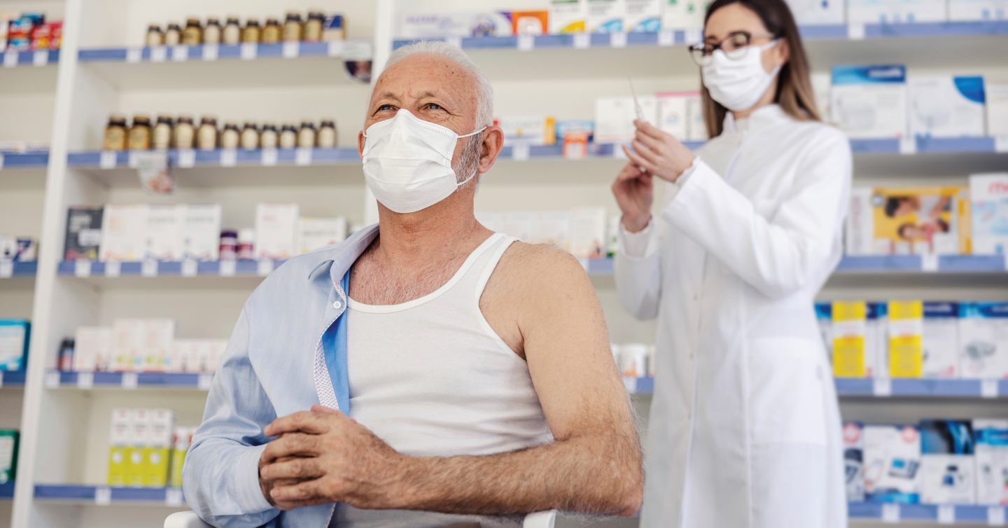 Person receiving vaccine from a pharmacist at a pharmacy