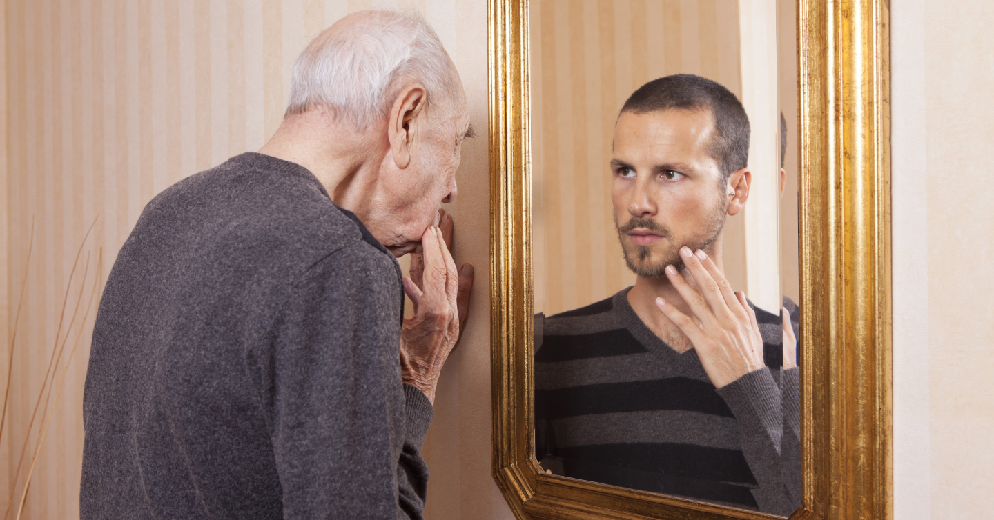 an older person looking in the mirror and seeing their younger self
