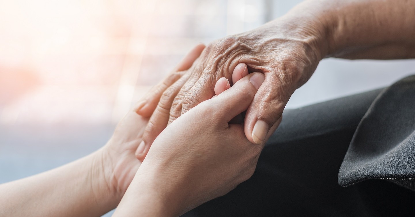 younger hand holding older hands