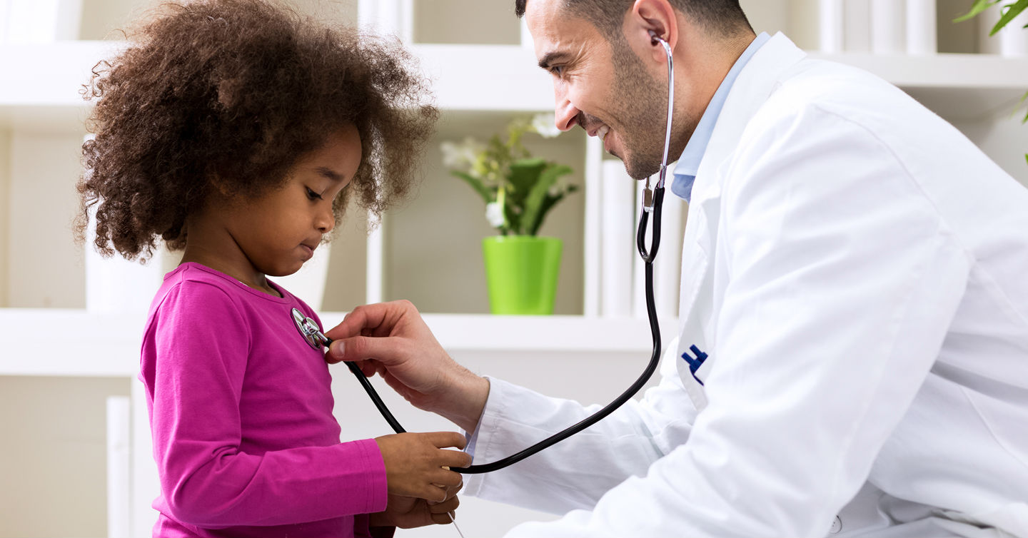doctor giving child annual well child visit checkup