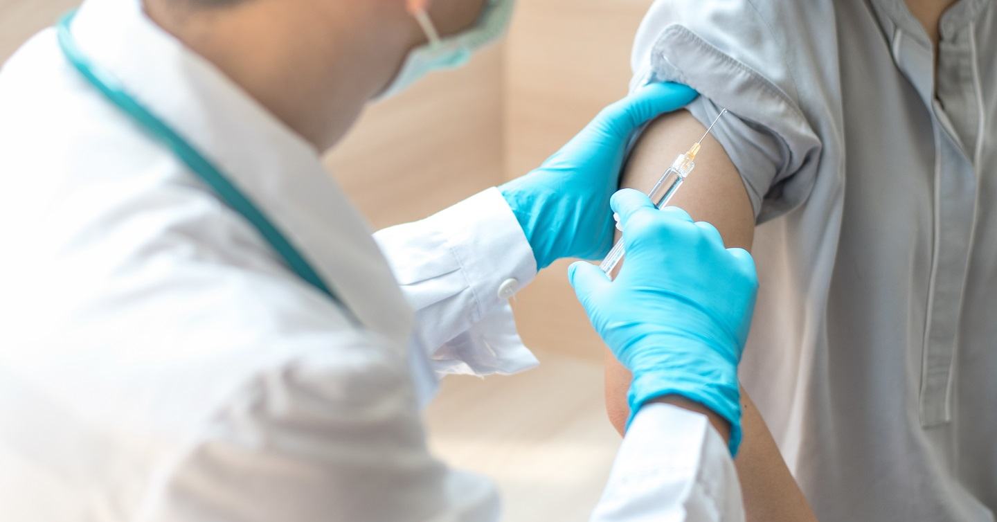 person standing next to doctor with needle in hand