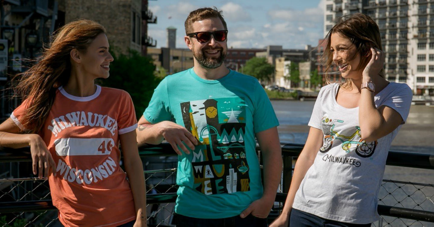 Brew City adorning three young adults standing on bridge over Milwaukee river