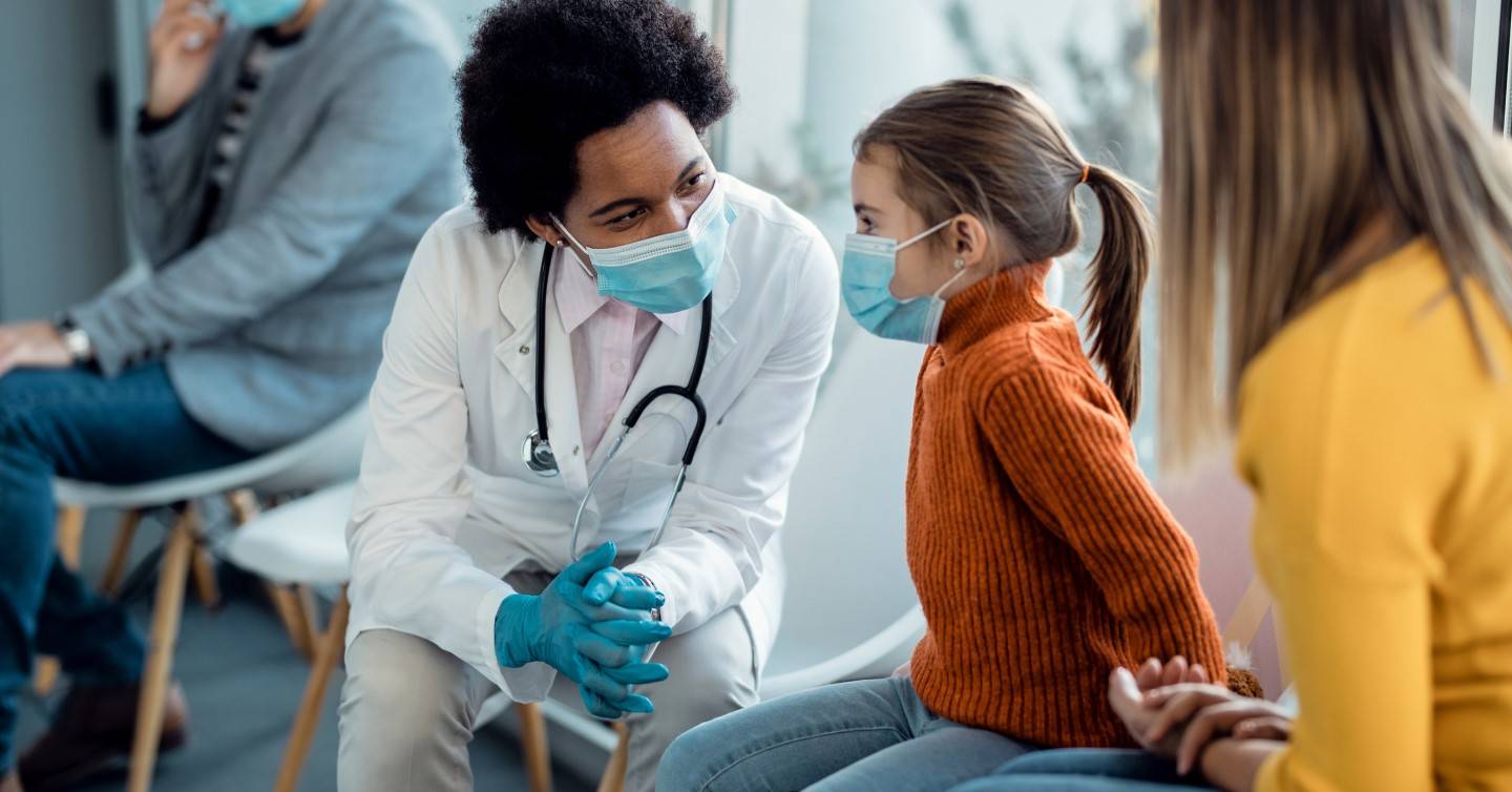 doctor talking to child and parent about immunization