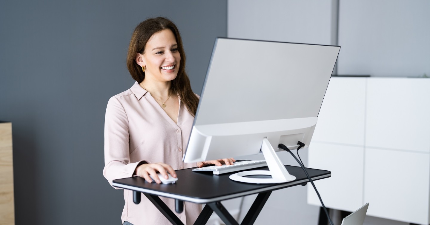 woman exhibiting good posture standing at her desk