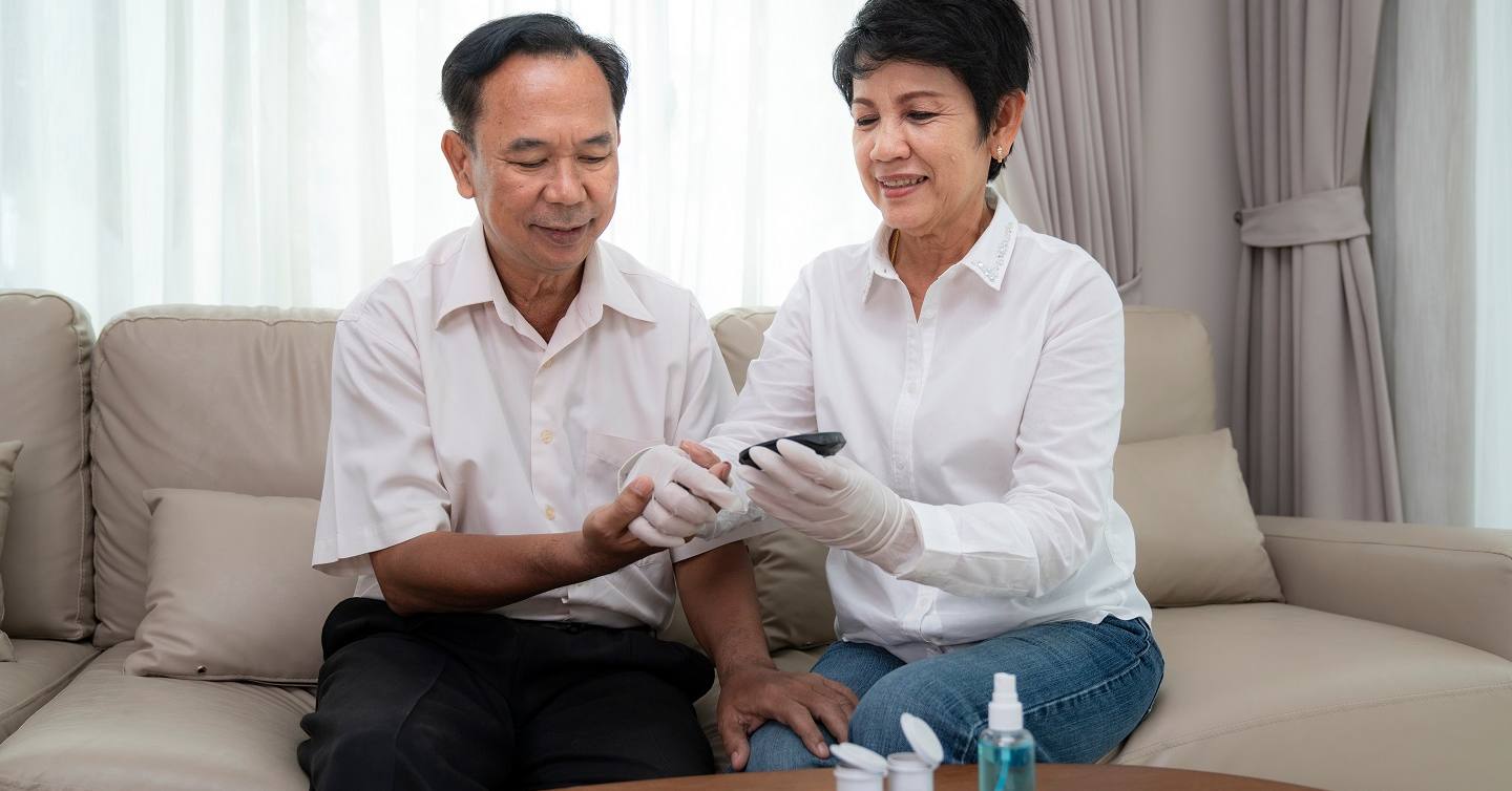 couple checking blood pressure on couch