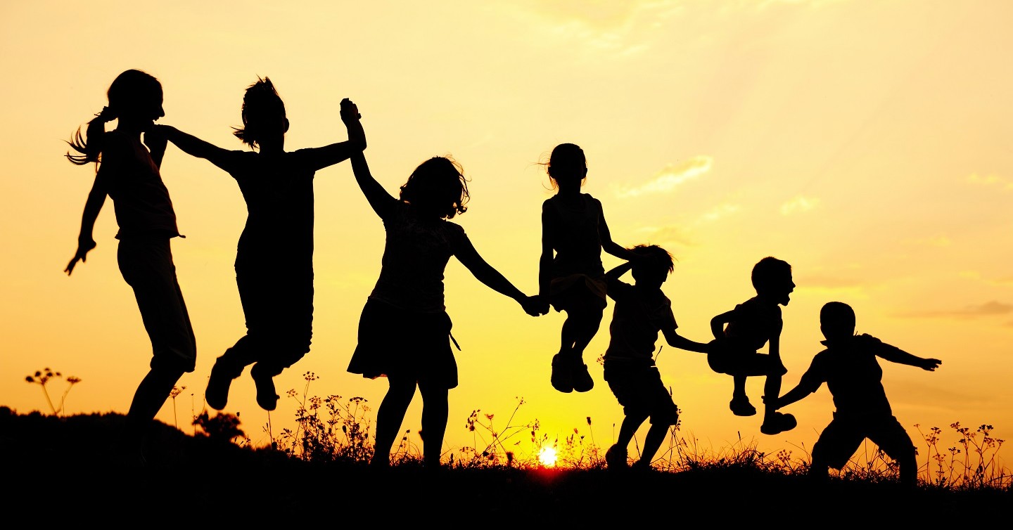 silhouettes of children playing in late day sunlight