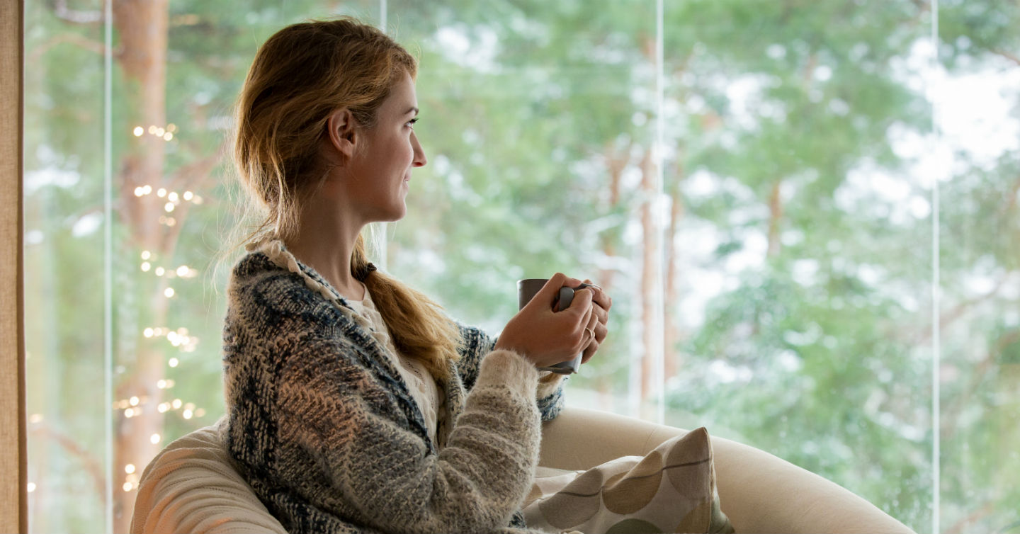 woman looking out window during pandemic