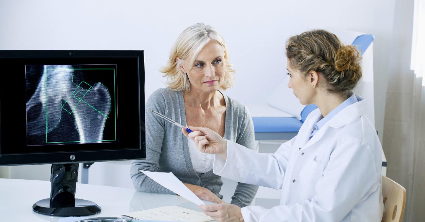 doctor showing woman bone density results