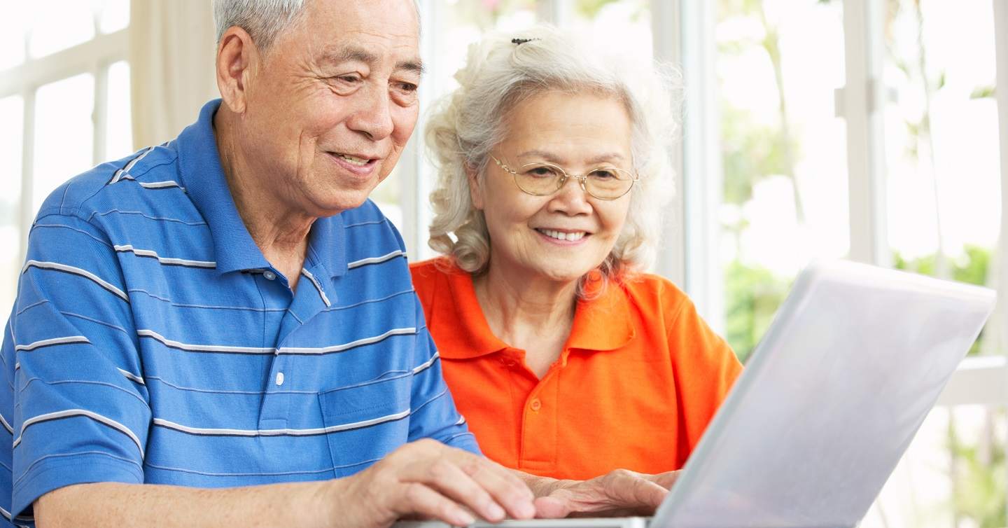 senior couple looking at annual notice of change document on computer