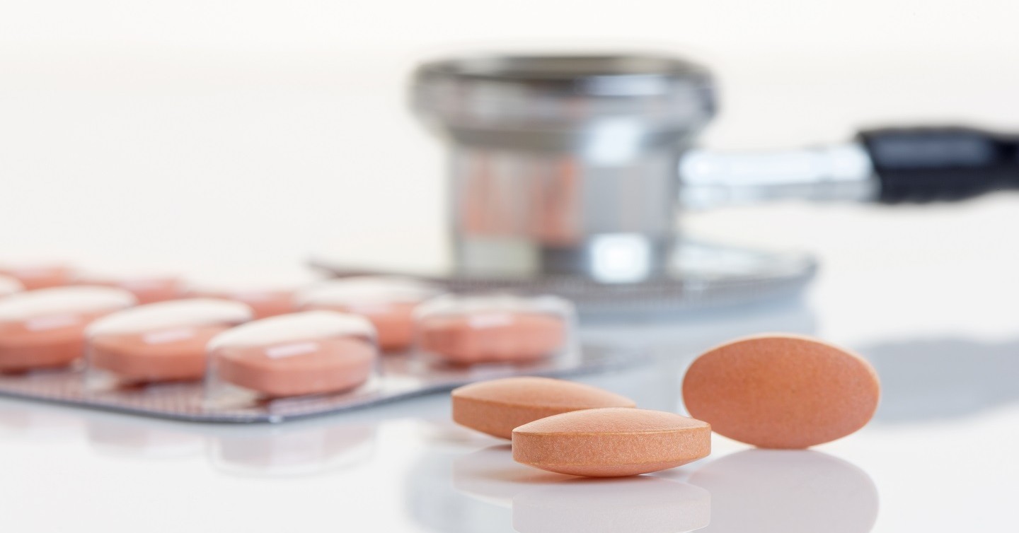 statin pills next to stethoscope on counter