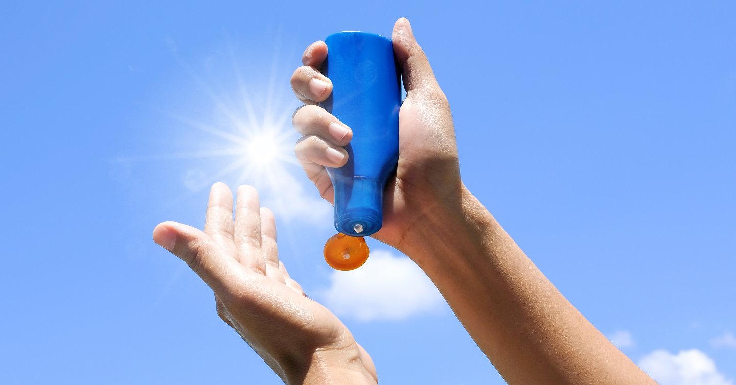 hand holding sunblock in front of sun